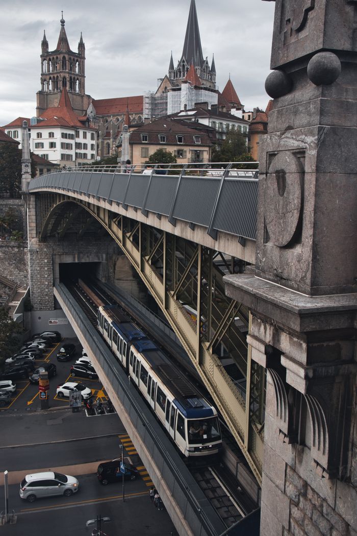 A scenic view of Lausannes metro system passing below the historic Cathedral Saint Pierre.