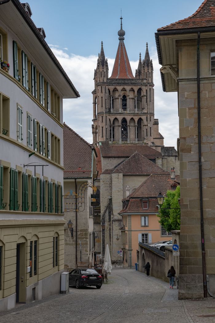 Charming city street leading to Lausanne Cathedral, showcasing historic architecture.